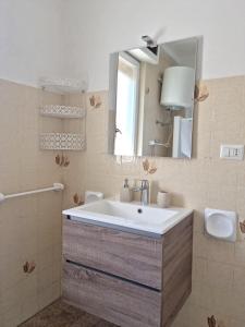 een badkamer met een wastafel en een spiegel bij One bedroom appartement at Calasetta 650 m away from the beach with enclosed garden and wifi in Calasetta