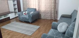 uma sala de estar com um sofá azul e uma cadeira em Apartament lux em Roman