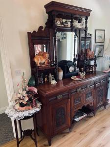 a wooden dresser with a mirror on top of it at Cutteen Cottage in Tulla