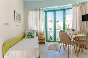 mały pokój z łóżkiem, stołem i oknem w obiekcie Theseus Zen Luxury Suite - Natural Living w Heraklionie