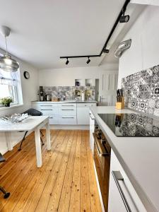 cocina con armarios blancos y suelo de madera en Schönes City-Apartment mit 2 Schlafzimmer, Parkplatz, ruhig und hell, D46-DG, en Oldenburg