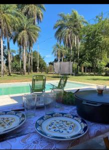 a table with plates and glasses on a table with a pool at Santas Hogar in Santa Ana