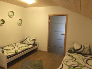 FriesenriedにあるFerienhaus am Waldのベッドルーム1室(ベッド2台付)、開閉ドアが備わります。