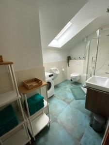 ein Badezimmer mit einem Waschbecken, einem WC und einem Waschbecken in der Unterkunft Ferienhaus am Wald in Friesenried