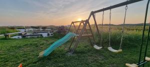 um parque infantil com um escorrega num campo em Gite Bannost em Bannost