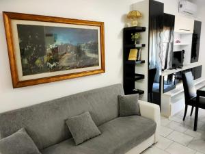 a living room with a couch and a painting on the wall at Nomentum House in Mentana