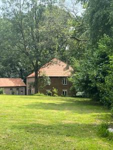 a house in the middle of a green field at B&B Le Manoir de la Douve in Heuvelland