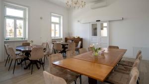 a dining room with tables and chairs and a chandelier at Kira Panzió in Lengyeltóti