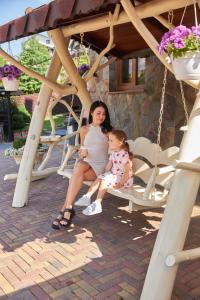 a woman and a little girl sitting on a swing at Mountain Krystal in Bukovel