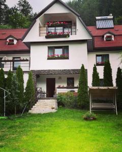 a white house with a red roof and a yard at Montagnoli Luxury Villa in Cluj-Napoca