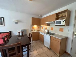 a small kitchen with a table and a microwave at Le Green in Levernois