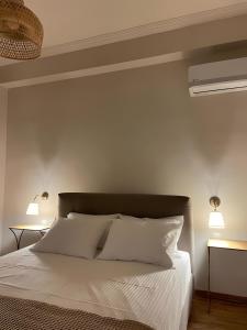 een slaapkamer met een bed met witte lakens en 2 lampen bij Luxurious Apartment in the Heart of Athens in Athene