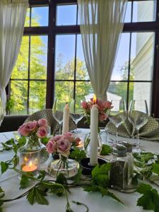 Arbottna Herrgård AB في Muskö: طاولة عليها الشموع والزهور
