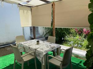 una mesa y sillas en un patio con un mantel blanco en Artur holiday city - double room en Gomec