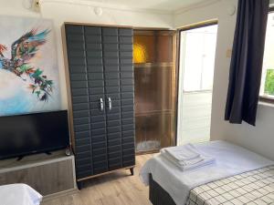1 dormitorio con 1 cama, TV y puerta corredera en Artur holiday city - double room, en Gomec