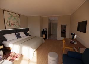 1 dormitorio con cama, escritorio y sofá en HENRI Country House Kitzbühel, en Kitzbühel