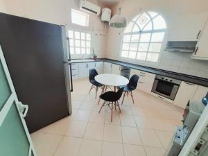 a kitchen with a table and chairs in it at Villa 9 Palms Beach in Ras al Khaimah