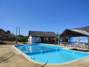 uma grande piscina azul em frente a uma casa em Auberge Le Lagon em Nosy-Be