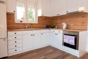 a kitchen with white cabinets and a sink at Villa Lotta & Nolla in Mostar