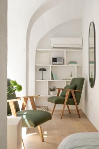 una habitación con 2 sillas verdes y una mesa en April1550 Boutique Hotel en Liubliana