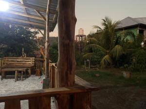 un banc en bois à côté d'un arbre dans une cour dans l'établissement Rocky Homestay Lakey, à Huu