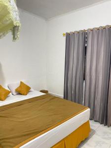 1 dormitorio con 1 cama y una ventana con cortinas en Rocky Homestay Lakey, en Huu