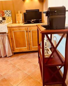 una cucina con bancone e televisore di Casa della Fattoria, Tuscany Chic Flat a La Cinquantina