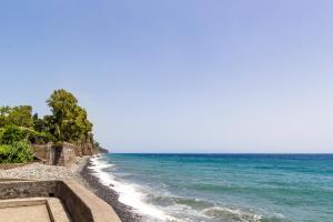 a beach with blue water and trees on it at Sea paradise - il mare sotto la finestra in Riposto