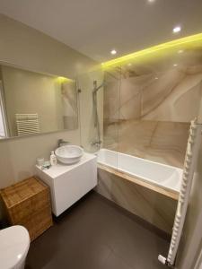 La salle de bains est pourvue d'un lavabo, d'une baignoire et de toilettes. dans l'établissement Luxurious apartment in the heart of Cluj-Napoca, à Cluj-Napoca