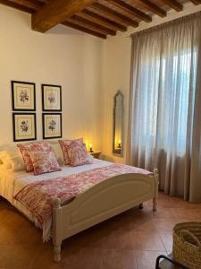 1 dormitorio con cama y ventana grande en Casa della Fattoria, Tuscany Chic Flat, en La Cinquantina