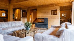 a living room with white couches and a fireplace at Chalets de l'Alpaga in Megève
