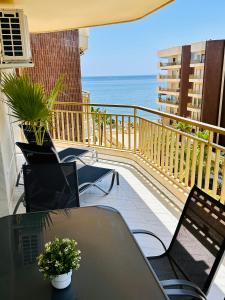 d'un balcon avec une table et des chaises donnant sur l'océan. dans l'établissement Playa Dona Sofia Bella, à Fuengirola