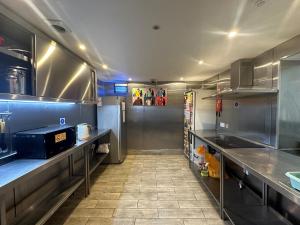 a large kitchen with stainless steel counters and appliances at Smart Hyde Park Inn Hostel in London