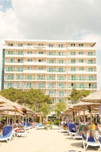 un hotel en la playa con sillas y sombrillas en Albanian Star Hotel, en Golem