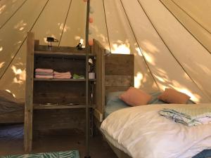 ein Schlafzimmer mit einem Bett in einem Zelt aus Leinwand in der Unterkunft SUZE LUXE NATURE in Suze-la-Rousse