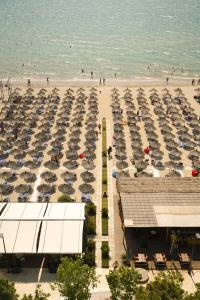 eine Luftansicht auf einen Strand mit einem Haufen Regenschirme in der Unterkunft Albanian Star Hotel in Golem