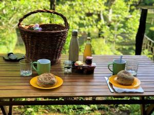 a picnic table with two plates of food and a basket at Le Moulin du Luech in Peyremale