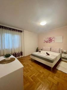 een slaapkamer met een bed en een houten vloer bij Apartments Zenta Split in Split
