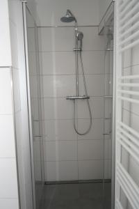 ein Bad mit einer Dusche und einer Glastür in der Unterkunft Strandhaus Döse 1 in Cuxhaven