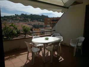 d'une table et de chaises blanches sur un balcon avec vue. dans l'établissement Porto Azzuro Apartment 6 Beds, à Porto Azzurro