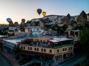 um grupo de balões de ar quente sobrevoando um edifício em Nomads Cave Hotel & Rooftop em Goreme