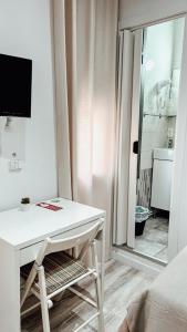een wit bureau in een kamer met een raam bij Hostal Ruta de Francia in Barcelona