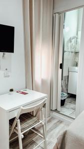 Un escritorio blanco en una habitación con ventana. en Hostal Ruta de Francia, en Barcelona