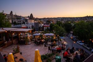 een groep mensen die aan tafel zitten in een stadsstraat bij Nomads Cave Hotel & Rooftop in Goreme