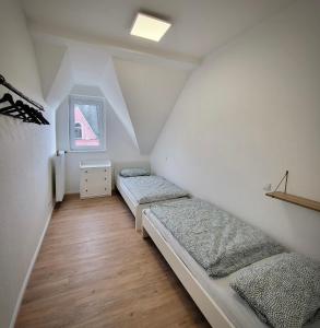 a attic room with two beds and a window at Ferienwohnung Jonathan in Koblenz