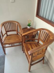 two wooden chairs sitting next to a table at Kubu Di-Kayla's in Sanur