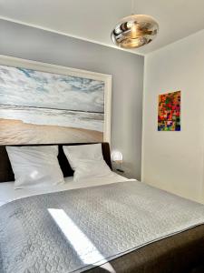 um quarto com uma cama com um quadro na parede em Geräumiges City-Apartment mit 2 Badezimmer und Parkplätzen D46-OG em Oldenburg