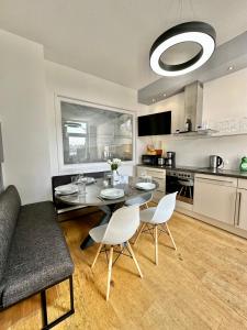 - une cuisine et une salle à manger avec une table et des chaises dans l'établissement Geräumiges City-Apartment mit 2 Badezimmer und Parkplätzen D46-OG, à Oldenbourg