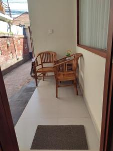 a balcony with two chairs and a table at Kubu Di-Kayla's in Sanur