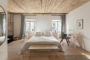 a bedroom with a large bed with a wooden ceiling at April1550 Boutique Hotel in Ljubljana